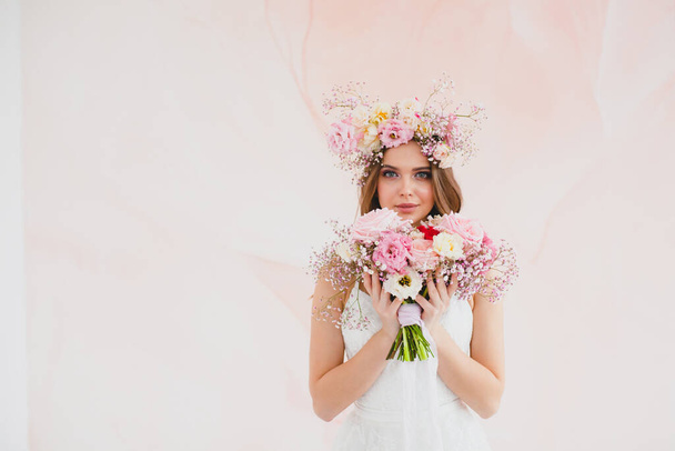 Portrait of beautiful bride with flower wreath on her head and bridal bouquet - Φωτογραφία, εικόνα