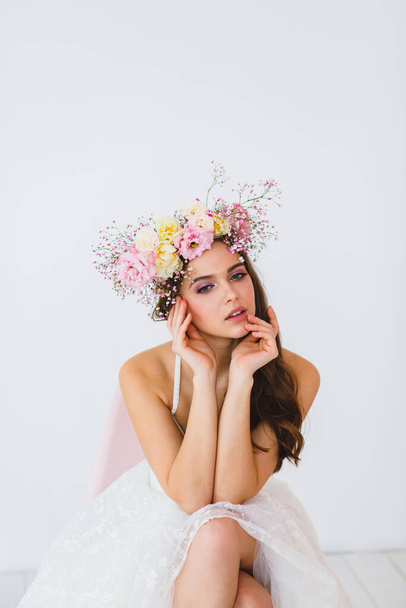 Portrait of beautiful bride with flower wreath on her head at white background - Photo, image