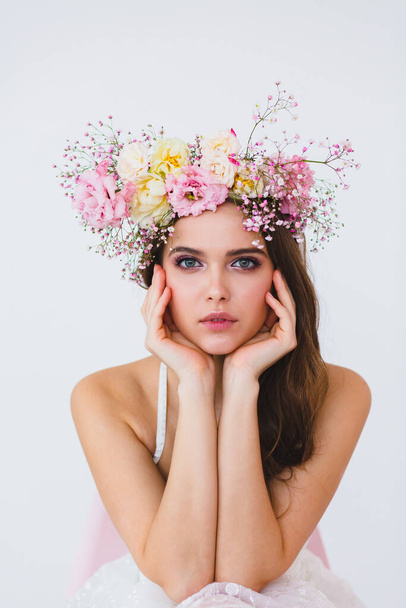 Portrait of beautiful bride with flower wreath on her head at white background - Foto, imagen