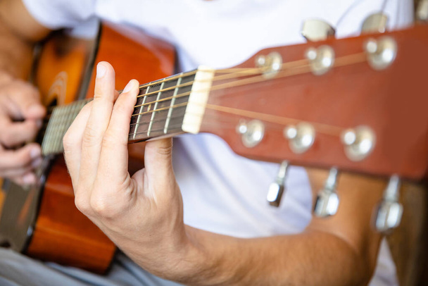 close-up van een akoestische gitarist - Foto, afbeelding