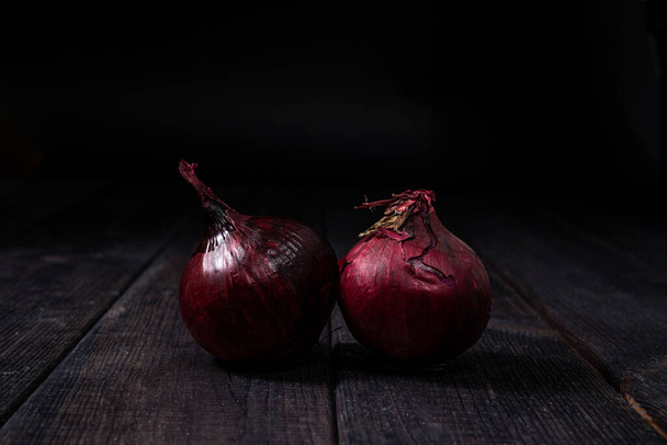 Red onion on a wooden background. The concept of food and cooking. Eating vegetables and healthy nutrition. Eating red onions, adding to dishes. - Zdjęcie, obraz