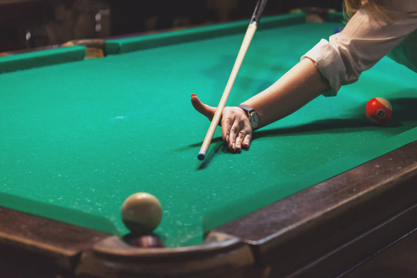 hand of a girl playing billiards, trying to hit the ball, retro toned - 写真・画像