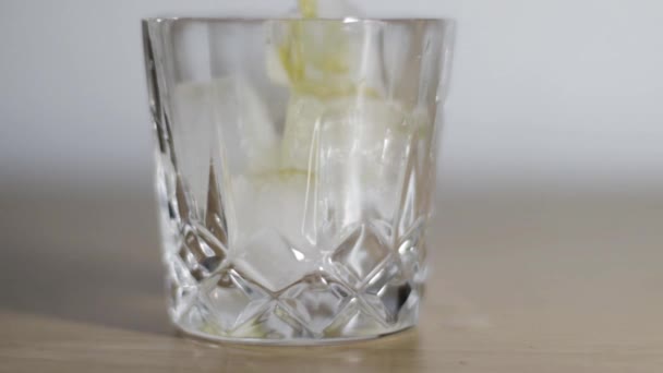 Whiskey in a glass. Yellow whisky drink. Alcoholic beverage in a glass. - Video