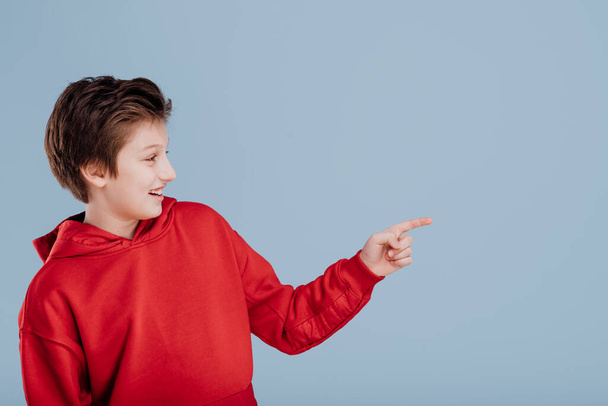 Happy boy pointing with finger in side direction - Φωτογραφία, εικόνα