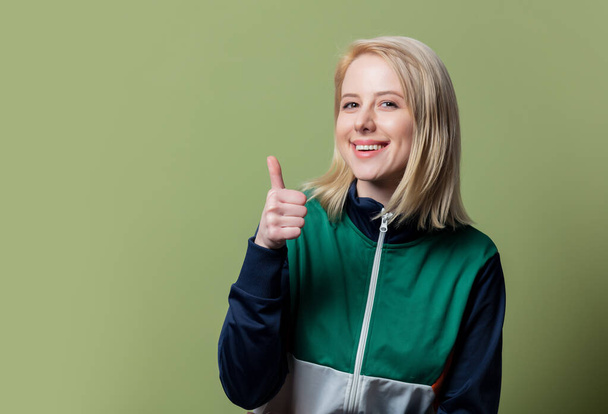 Style blonde woman in 80s clothes on green background - Valokuva, kuva