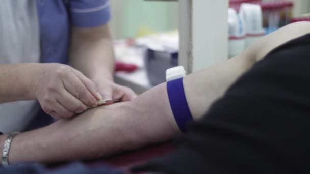 Inyectar una aguja en la mano del paciente por parte de un trabajador médico. Nurso. Donación de sangre. Hospital. - Metraje, vídeo