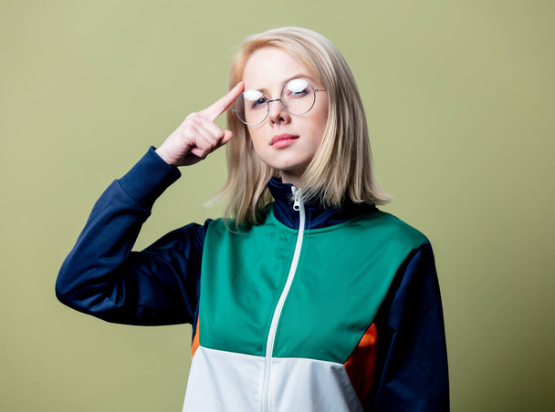 Sorpresa donna bionda in abiti anni '80 e occhiali su sfondo verde
  - Foto, immagini