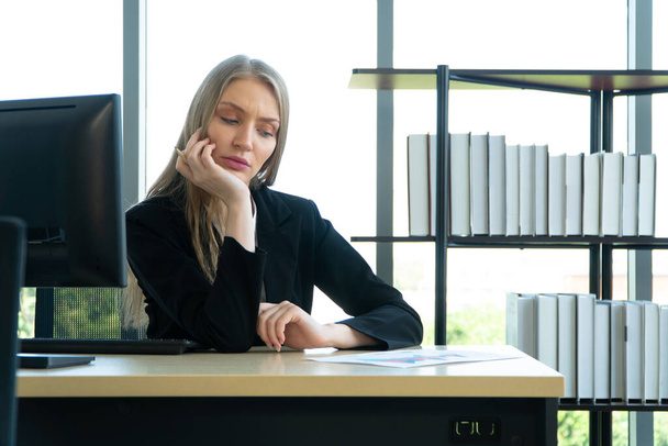 Серйозна білоруська бізнес-леді, що працює за офісним столом, виглядає втомленою і напруженою. Концепція проблем нових підприємців не здатна успішно вести бізнес
 - Фото, зображення