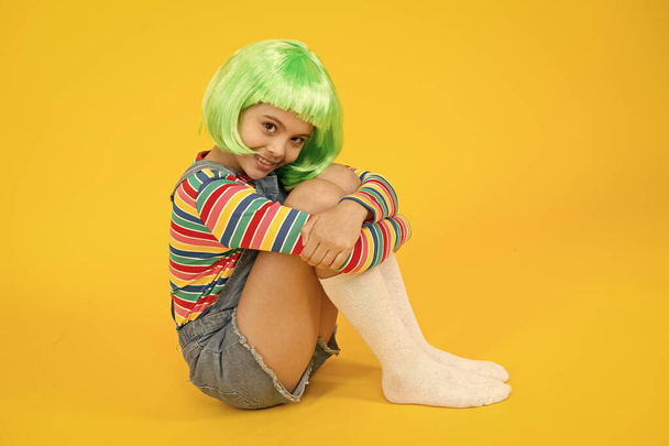 Kid girl with bright vibrant hairstyle. Artificial wig concept. Semi permanent color cream. Colored clip in hair extensions. Change color. Pigment dye hair. Freedom for expression. Fantasy hair trend - 写真・画像