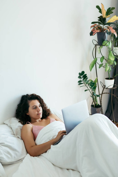 nő laptoppal az ágyban szabadúszó internetes vásárlás - Fotó, kép