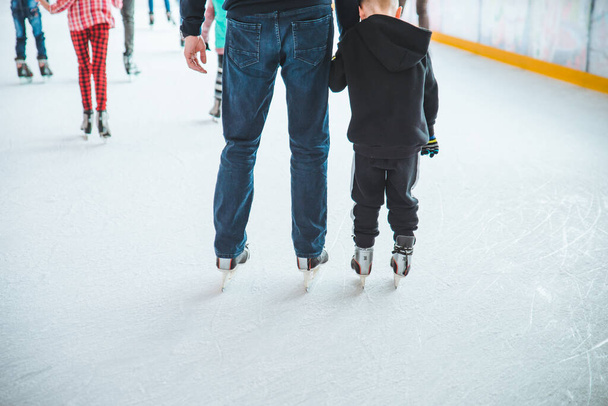 リヴィウ、ウクライナ - 2019 年 2 月 3 日: 父が息子にスキー スケート リンクでスケートをする方法を教えます。家族の時間 - 写真・画像