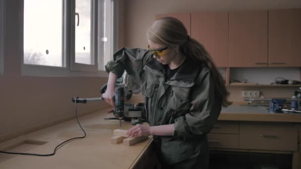 Girl screwing a screw into a wooden blank - Filmagem, Vídeo