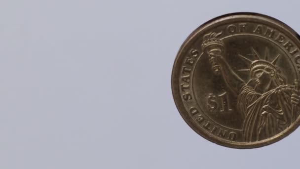 Girando moneda de 1 dólar sobre fondo blanco
 - Imágenes, Vídeo