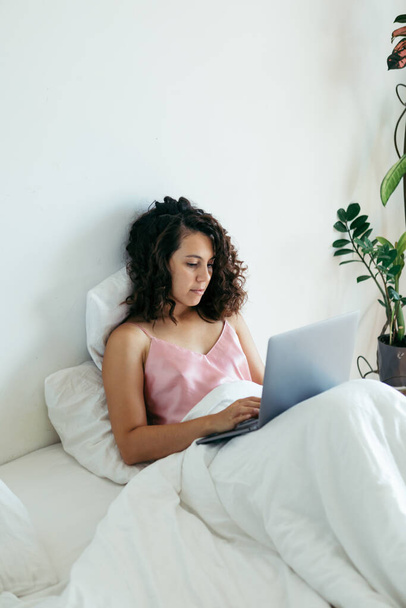 woman with laptop in bed freelancer internet shopping - Foto, Bild