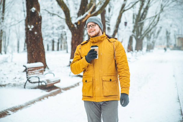 muž pití kávy v městském parku. životní styl. příležitostné. zasněžovaných zimních - Fotografie, Obrázek