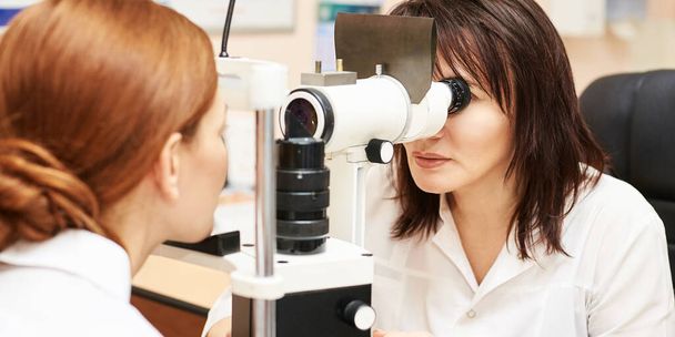 ophthalmologist doctor in exam optician laboratory with female patient. Eye care - Fotoğraf, Görsel