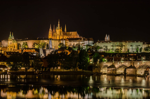 Karelsbrug en St Vitus kathedraal 's nachts in Praag Tsjechië - Foto, afbeelding
