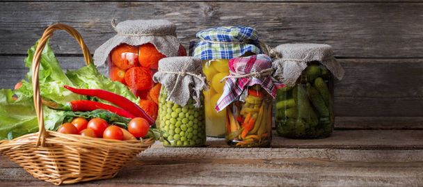canned vegetables in jars on wooden background - Photo, image