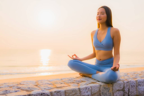 Portrét mladá asijská žena dělat meditaci kolem moře pláž oceán při východu slunce pro zdraví - Fotografie, Obrázek