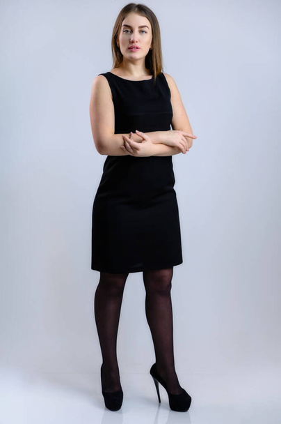 Full-length vertical portrait of a pretty business woman in full-length in a black dress on a white background - Fotografie, Obrázek