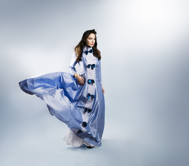 mor elbise gri artalan üzerinde sallayarak olarak kadın - Fotoğraf, Görsel