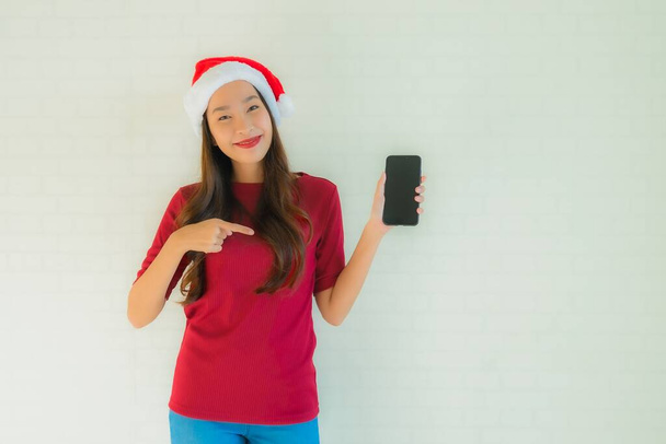 Portrait beautiful young asian women wear santa christmas hat with use smart mobile phone - Valokuva, kuva