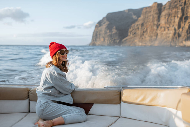 Žena cestující na jachtě u skalnatého pobřeží - Fotografie, Obrázek
