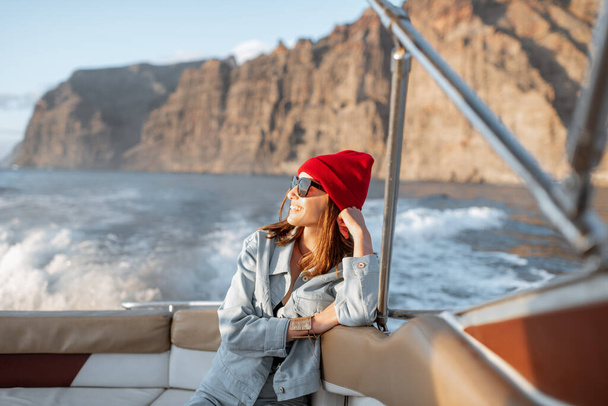 Femme voyageant sur un yacht près de la côte rocheuse
 - Photo, image