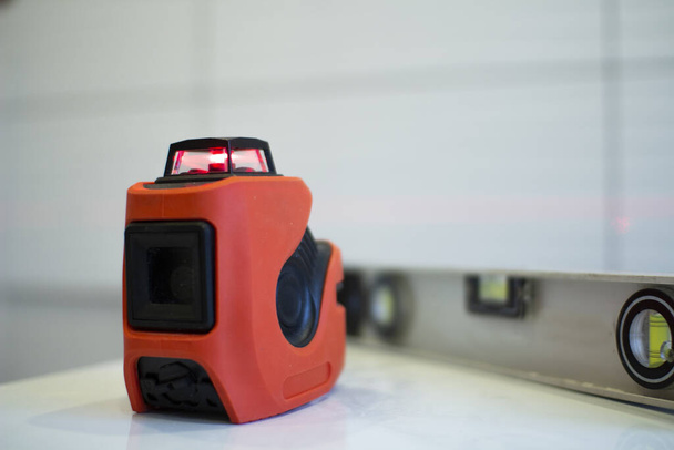 Laser level, used in apartment renovation. Optical instrument for accurate horizon level. - Zdjęcie, obraz