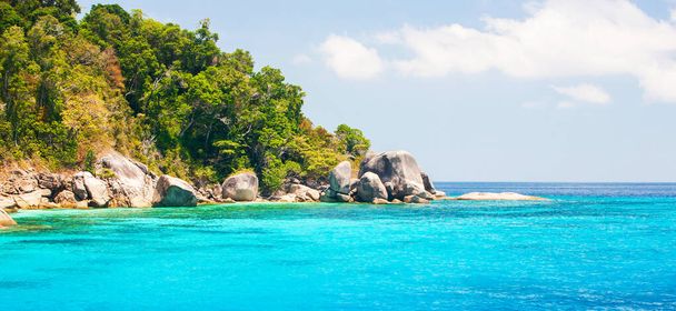 Maravilloso paisaje de islas Similan en verano soleado, agua de mar turquesa de cristal pintoresco contra las islas tropicales, nubes blancas y cielo azul en los fondos. Parque Nacional Mu Ko Similan, Tailandia
. - Foto, Imagen