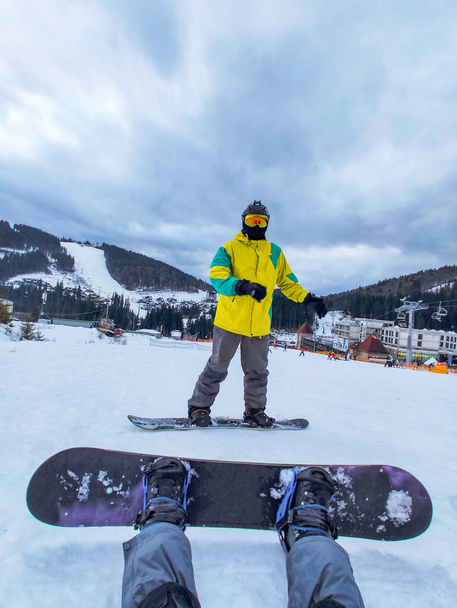egy pár ül a havas dombon snowboarddal. téli tevékenységek. Személynézet - Fotó, kép