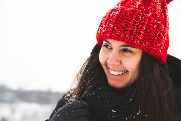 Porträt einer jungen hübschen Frau mit rotem Hut und bubo lächelnd. Winterzeit - Foto, Bild
