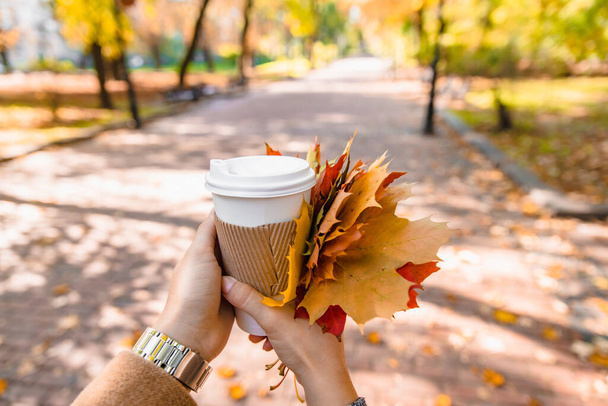 Nainen tilalla kahvikuppi juoda mennä syksyllä syksyllä kausi keltaiset lehdet - Valokuva, kuva