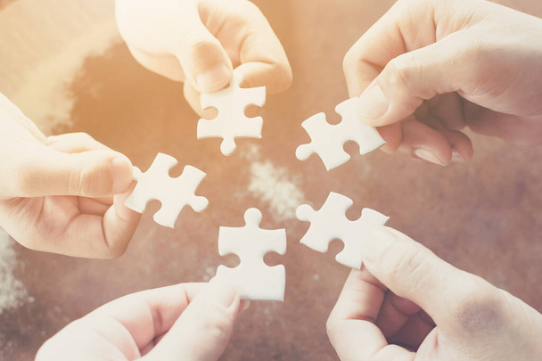 Hand of diverse people connecting jigsaw puzzle. Concept of partnership and teamwork in business - Photo, Image
