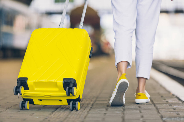 donna con borsa gialla alla stazione ferroviaria copia spazio - Foto, immagini