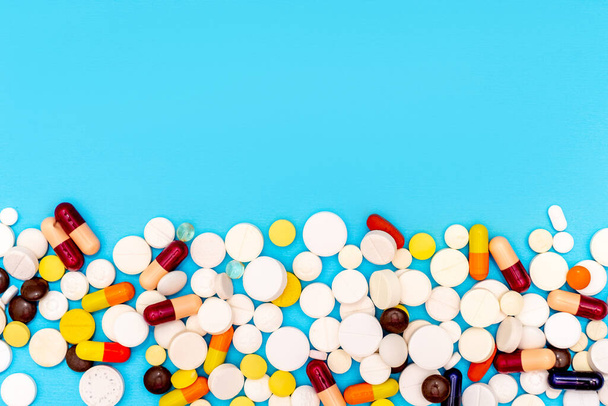 Différentes pilules sur fond bleu, vue du dessus et espace pour le texte
 - Photo, image