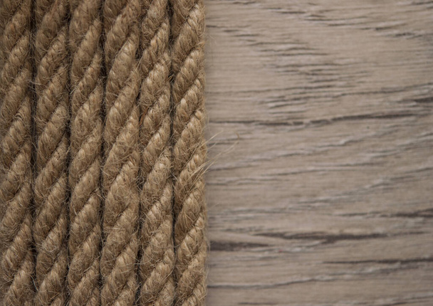 Close-up of a thick hemp rope. Natural rope on an old wooden table. Side view. Soft focus.  - Photo, Image
