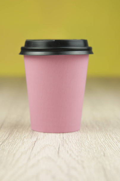 Único copo de papel rosa de café no chão de madeira velha
. - Foto, Imagem