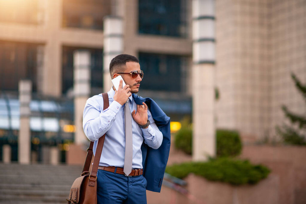 Ritratto di giovane uomo d'affari utilizzando smart phone outdoors.Business concetto
. - Foto, immagini