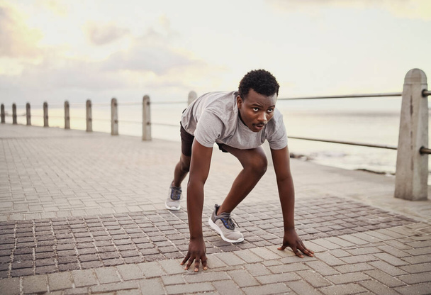 Молодой спортсмен готов к пробежке на тренировке на набережной утром
 - Фото, изображение