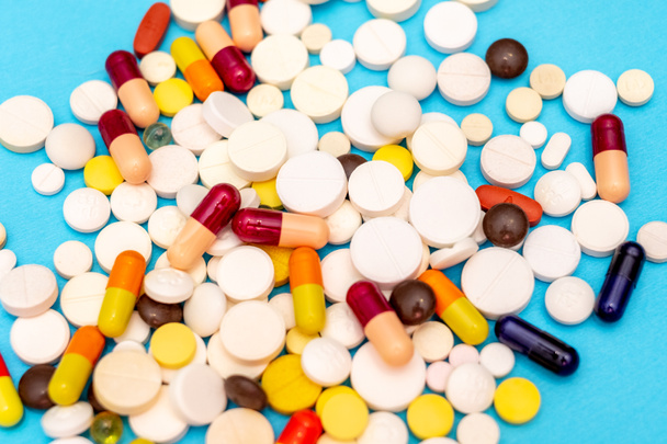 Varias píldoras sobre un fondo azul, vista superior de cerca
 - Foto, Imagen