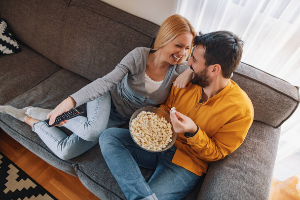 Portrait de couple heureux appréciant à la maison et regardant la télévision ensemble.Couple se préparant à regarder un film
. - Photo, image
