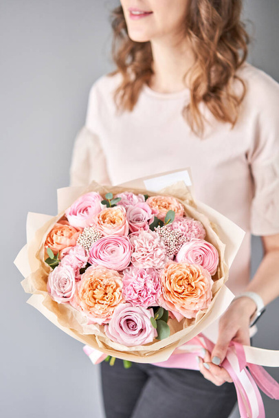 European floral shop. Beautiful bouquet of mixed flowers in womans hands. the work of the florist at a flower shop. Delivery fresh cut flower. - Фото, зображення