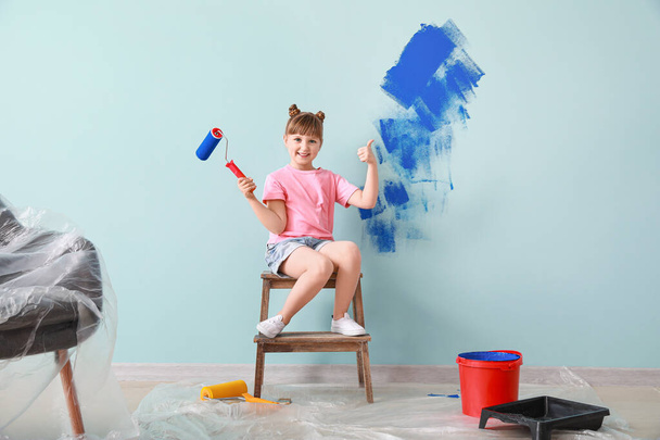 Little girl painting wall in room - 写真・画像