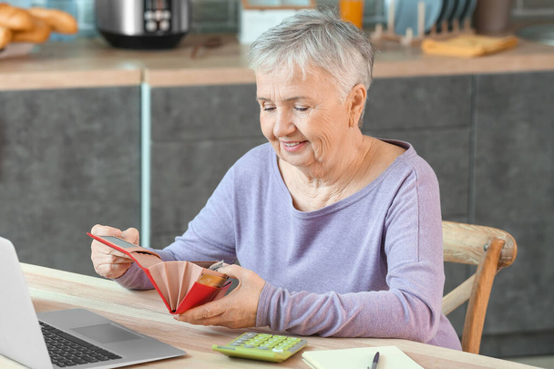 Senior woman counting money at home - Photo, Image