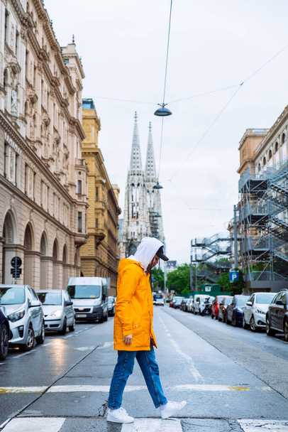 mujer cruzando calle vieja iglesia torres en fondo vienna austria
 - Foto, imagen