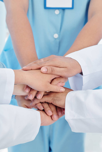 Крупним планом імідж працівників охорони здоров'я, які кладуть руки, щоб підтримувати один одного на довгий день роботи
 - Фото, зображення