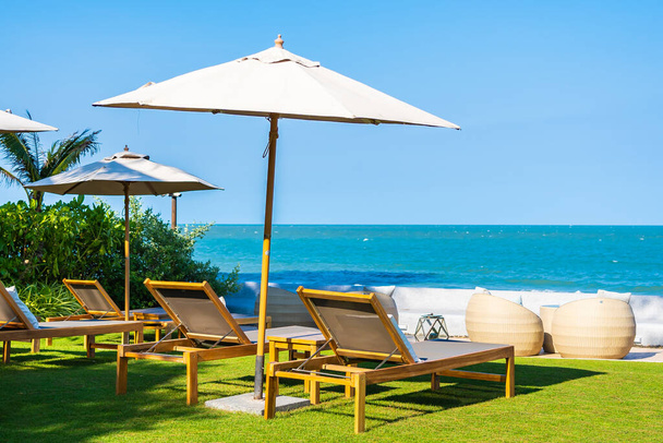 Paraplu en stoel rond strand zee oceaan voor reizen vakantie - Foto, afbeelding