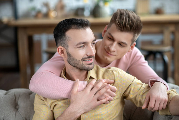 Young fair-haired man putting hand on his partners shoulder - Foto, Bild