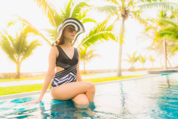 Портрет красива молода азіатка розслабляється навколо відкритого басейну в готельному курорті з пальмою на заході сонця або сходу сонця для відпочинку
 - Фото, зображення